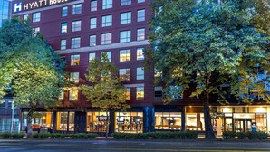 A modern hotel with a prominent sign, multiple floors, and a bar area visible at the ground level. - Hyatt House Seattle/Downtown (Seattle)