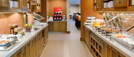 A buffet area with various food options and a coffee station.