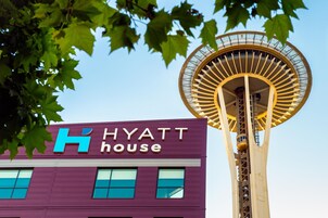 A building with a sign reading "HYATT house" and a large, circular, yellow structure in the background.