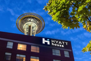 A hotel building with a large circular structure on top and a sign that reads "HYATT house".