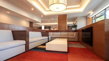 A modern living room with sofas, a coffee table, and a TV.