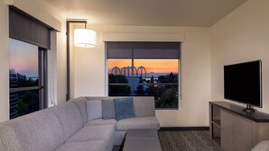 A modern hotel room with a large window, a flat-screen TV, a sofa, and a small table. - Hyatt House Seattle/Downtown (Seattle)