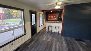 A hotel lobby with a reception desk, bar area, and large windows overlooking a street. - Moira Lake Motel (Madoc)