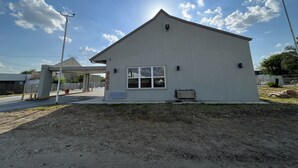 A small, single-story building with a flat roof and a large window. - Economy Hotel San Antonio  (San Antonio)