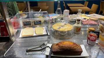 Un buffet de petit-déjeuner proposant une variété d'aliments et d'ustensiles.