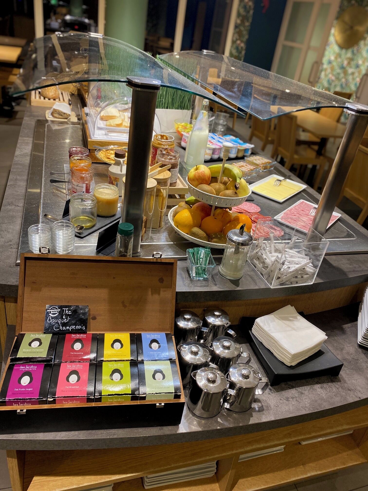 A breakfast buffet with various food items, condiments, and coffee options.