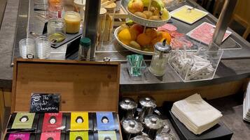 A breakfast buffet with various food items, condiments, and coffee options.