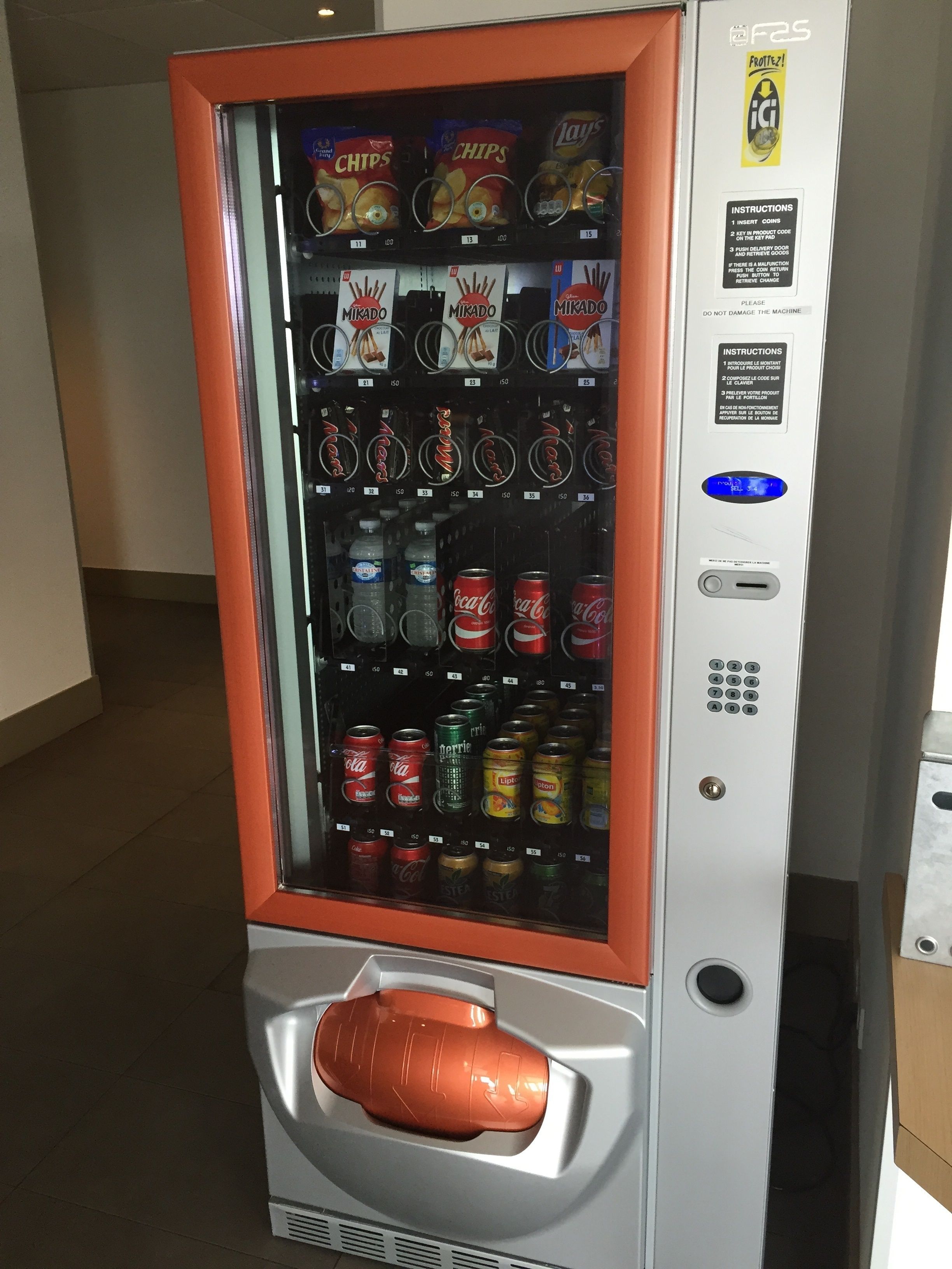 A vending machine with snacks, drinks, and a cash slot.