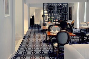 A hotel dining area with a patterned carpet, modern furniture, and a decorative wall. - Gamma de Fiesta Americana Monterrey Gran Hotel Ancira (Monterrey)