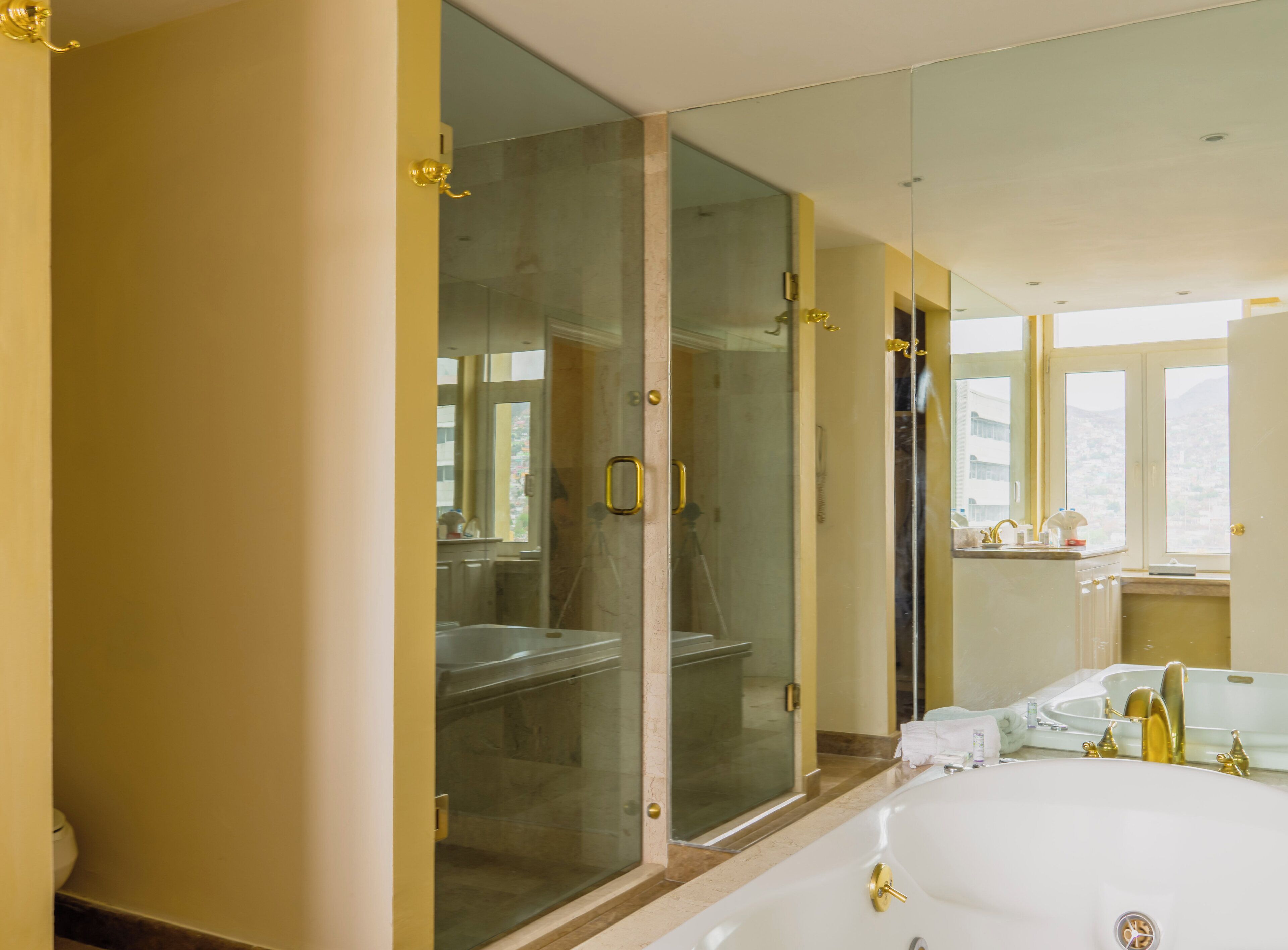 Un baño moderno con ducha de vidrio, una bañera grande y un tocador con espejo.