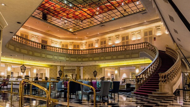 A multi-level hotel lobby with a grand staircase, checkered flooring, and a decorative ceiling. - Gamma de Fiesta Americana Monterrey Gran Hotel Ancira (Monterrey)