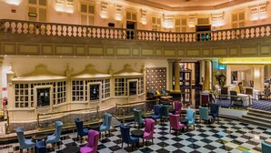 A hotel lobby with a checkered floor, multiple seating areas, and a balcony with railings. - Gamma de Fiesta Americana Monterrey Gran Hotel Ancira (Monterrey)