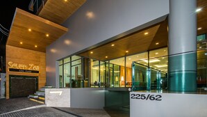 The exterior of a hotel with a modern design, featuring a prominent sign for 'Seven Zec Chic Hotel' and a staircase leading to the entrance.