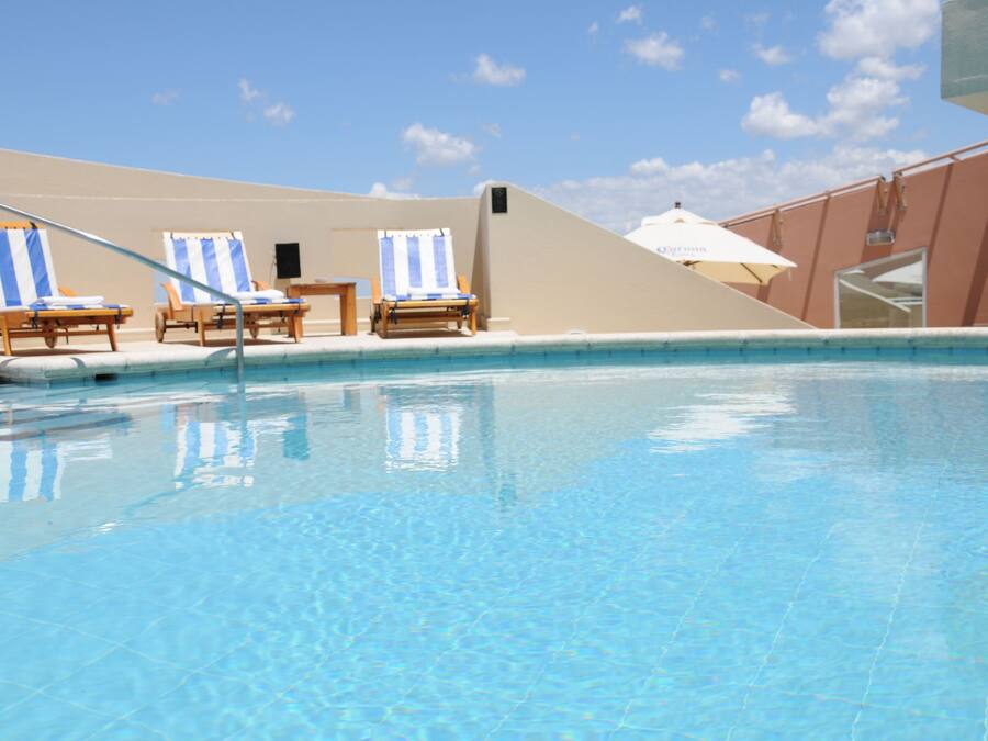 Una piscina al aire libre, tumbonas