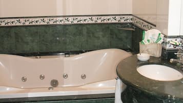 Un baño con bañera, lavamanos y espejo.