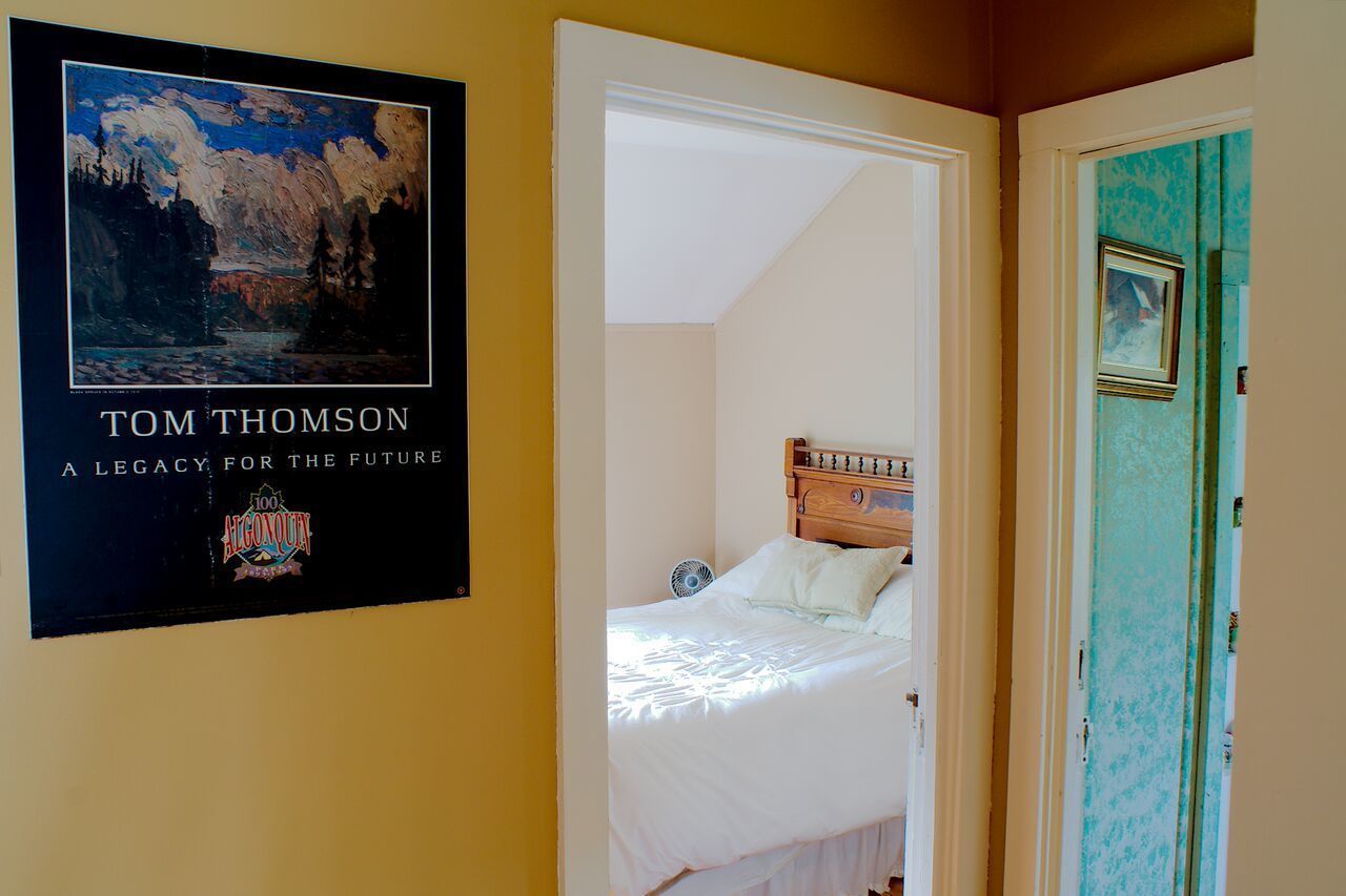 Un dormitorio con una cama, un cartel en la pared y una puerta con un marco.