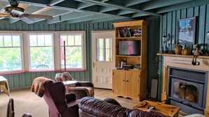 Una sala de estar acogedora con chimenea, estanterías de madera y televisor.