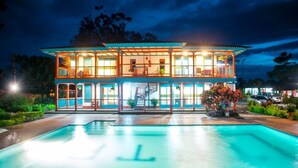 Un edificio de dos pisos con una piscina delantera.