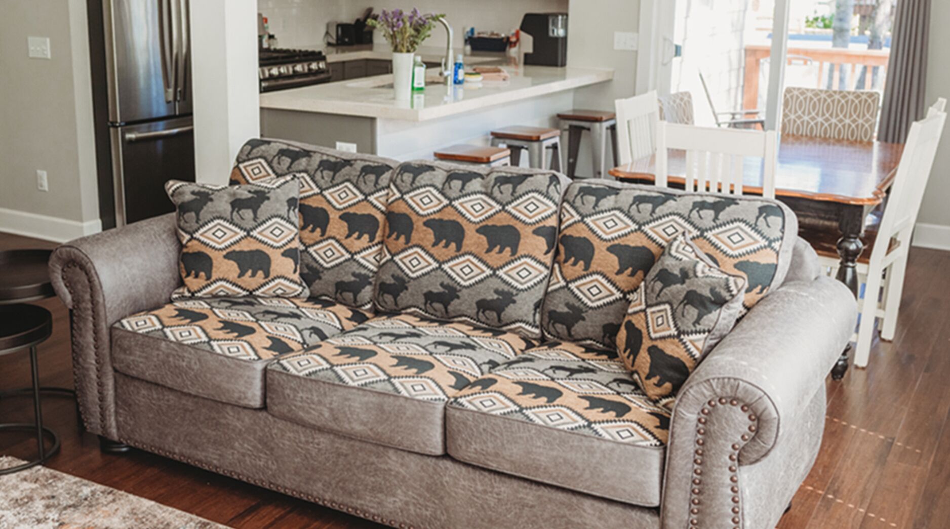 Ein graues Sofa mit gemusterten Kissen in einem Wohnzimmer.