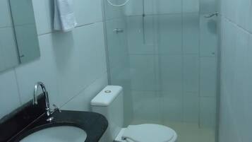 A bathroom with a sink, toilet, and glass-enclosed shower.