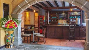 Un coin bar accueillant, agrémenté d’une arche en pierre rustique, de meubles en bois et d’une composition florale aux couleurs vives.