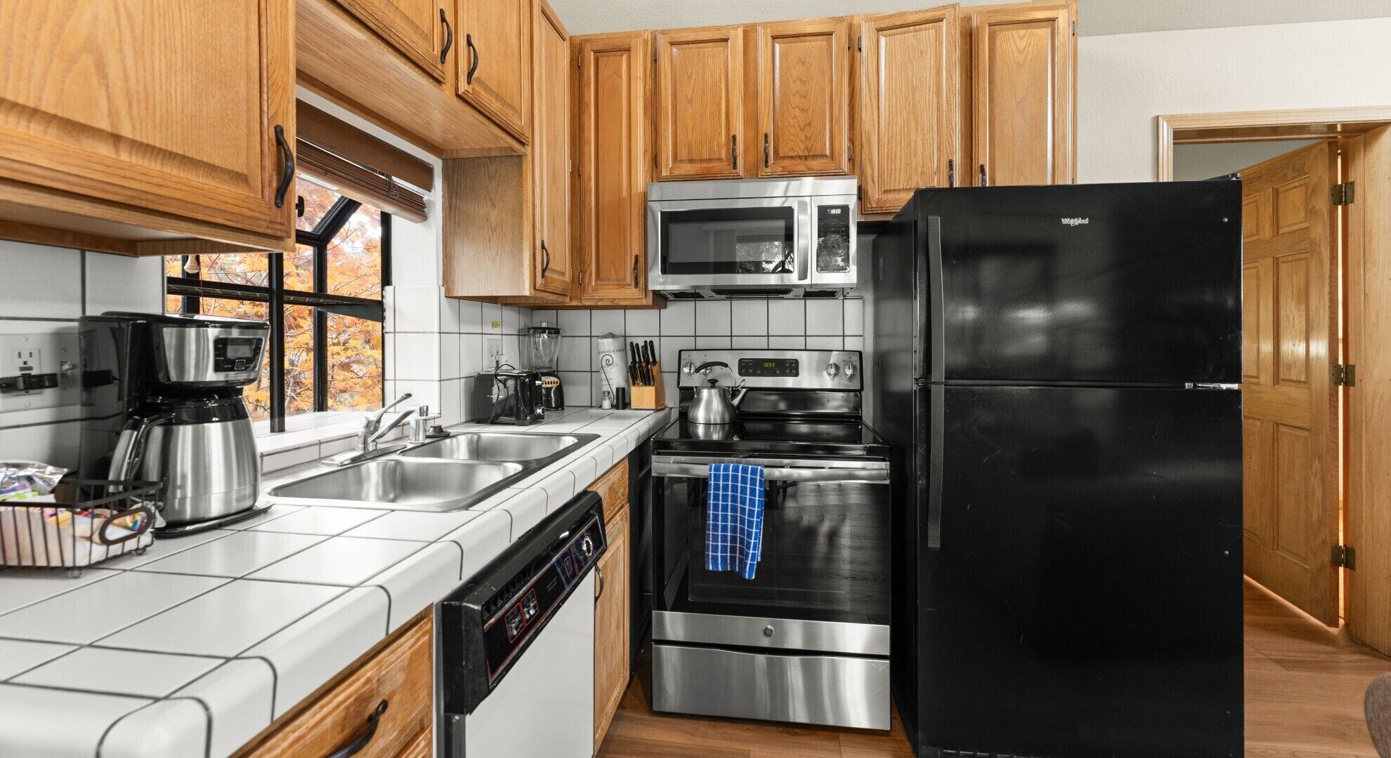 A modern kitchen with wooden cabinets, stainless steel appliances, and a dishwasher.