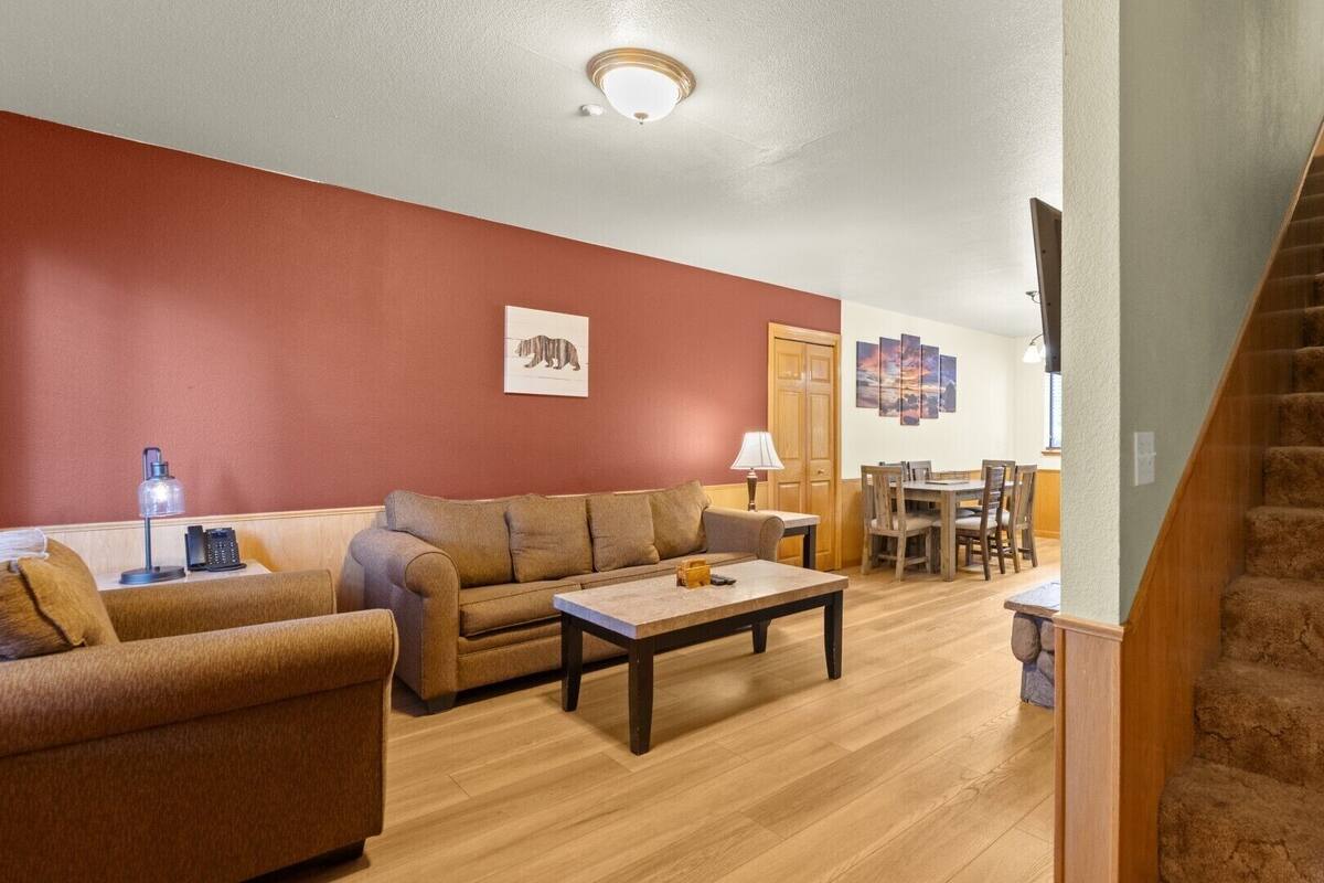 A living room with a sofa, coffee table, and a staircase.