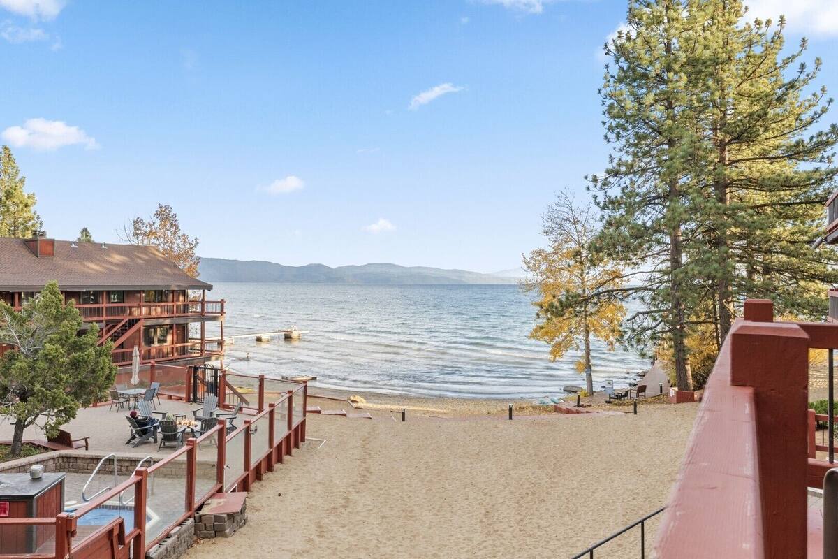A lakeside hotel with a pool, outdoor seating, and a view of the lake.