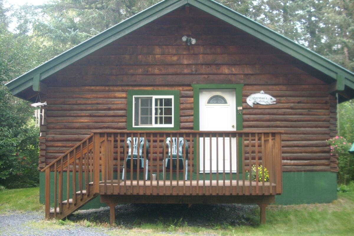A wooden cabin with a porch, a door, and a sign indicating it is a fisherman's cabin.