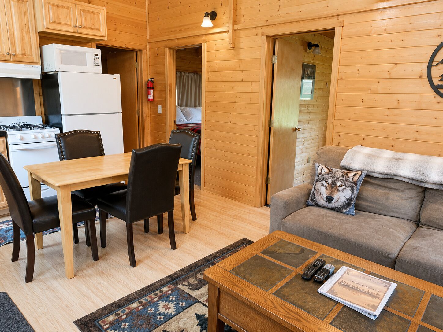 Un interior de cabaña acogedor con comedor, cocina y sala de estar.