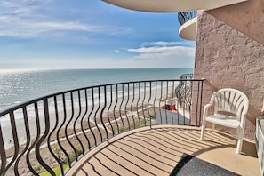 A balcony with a curved railing overlooking a beach. - Suites at the Beach (Myrtle Beach)