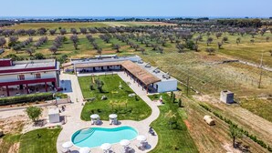 A resort with a swimming pool, outdoor seating, and a large building with multiple rooms. - Il Mondo dei Sogni (Nardò)