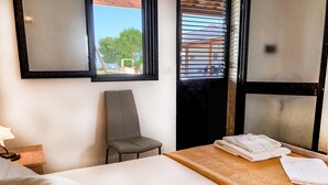 A hotel room with a bed, a chair, a window with blinds, and a view of the outdoors. - Il Mondo dei Sogni (Nardò)