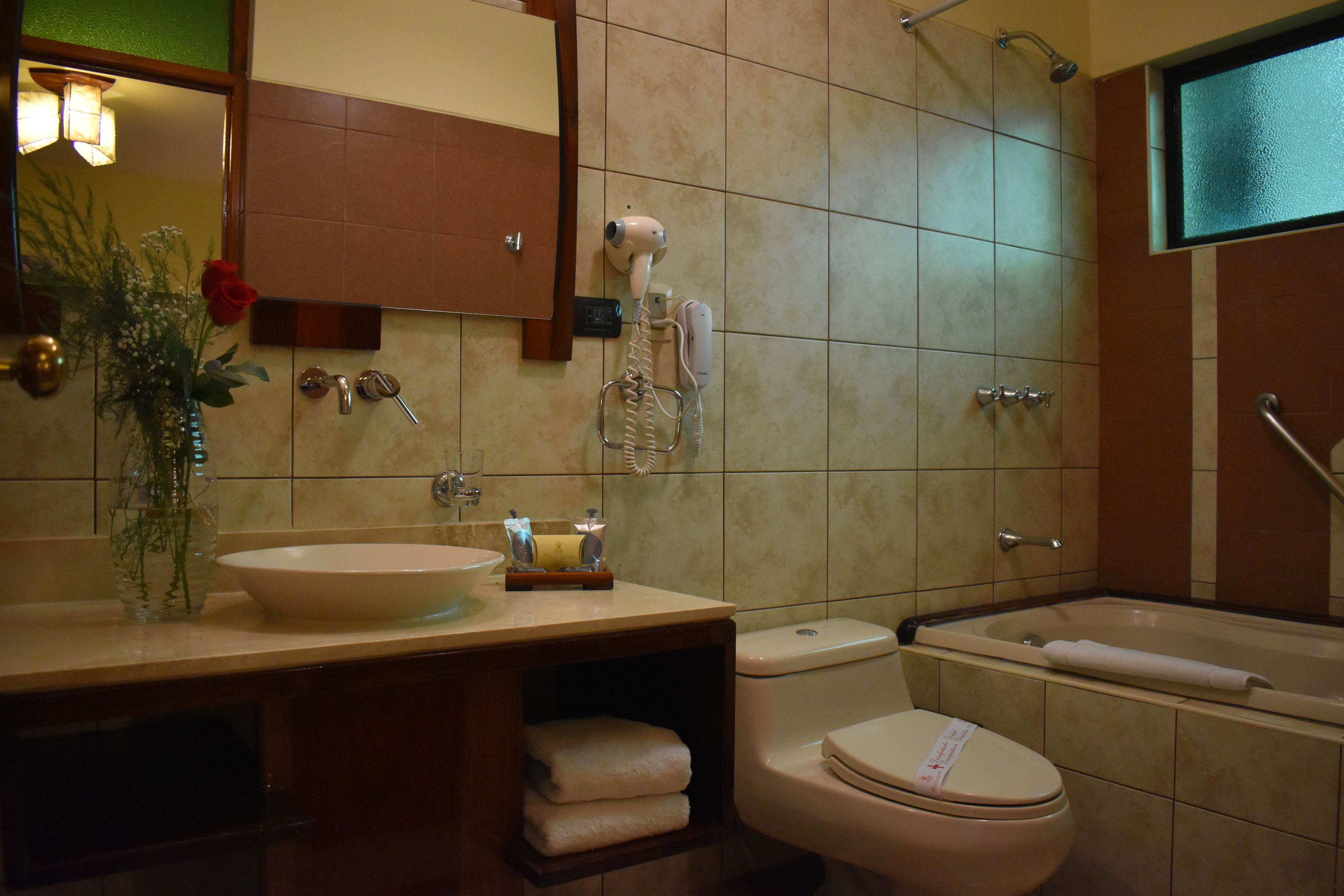 Un baño con lavamanos, inodoro y bañera.