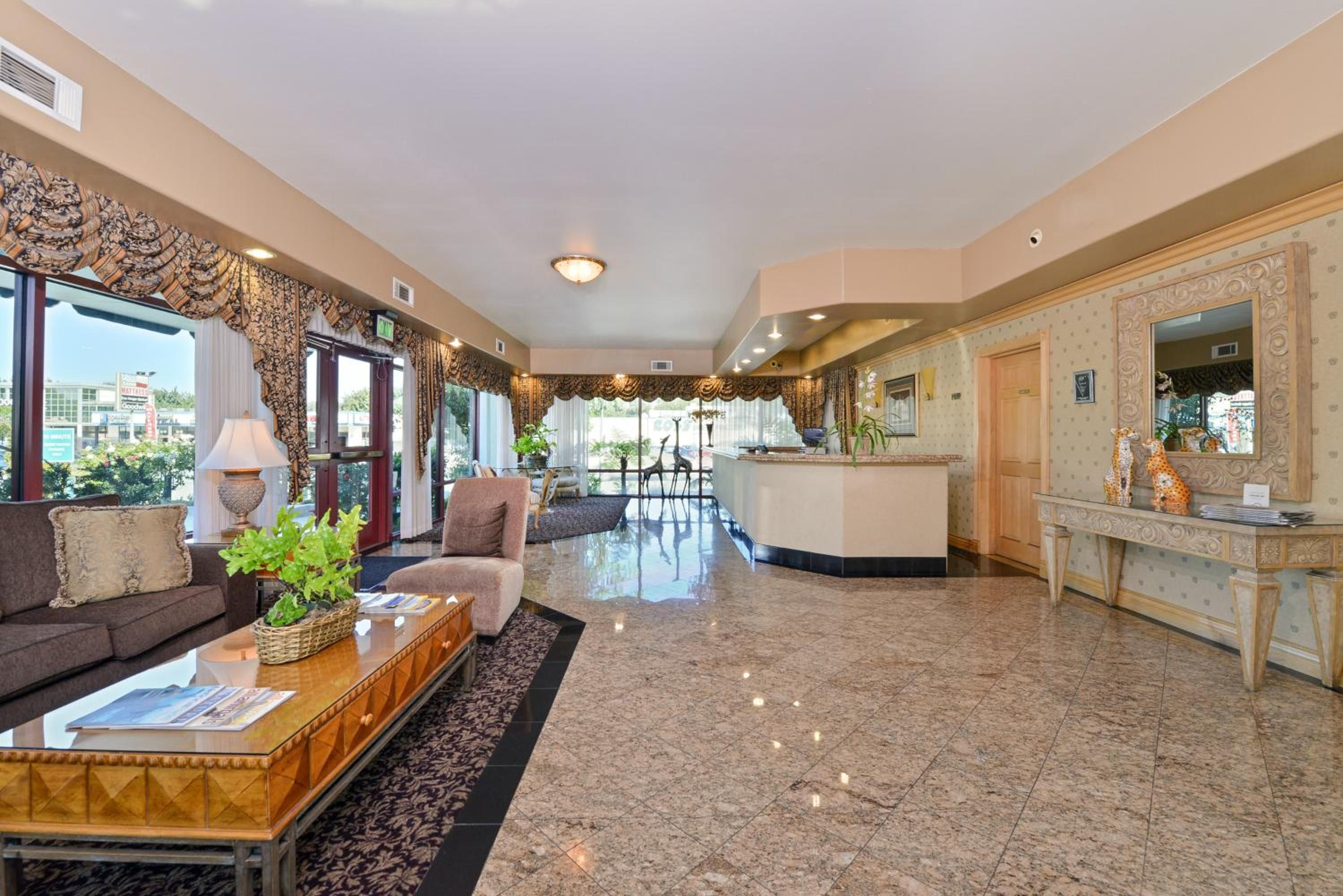 A spacious lobby with a reception desk, seating area, and large windows.