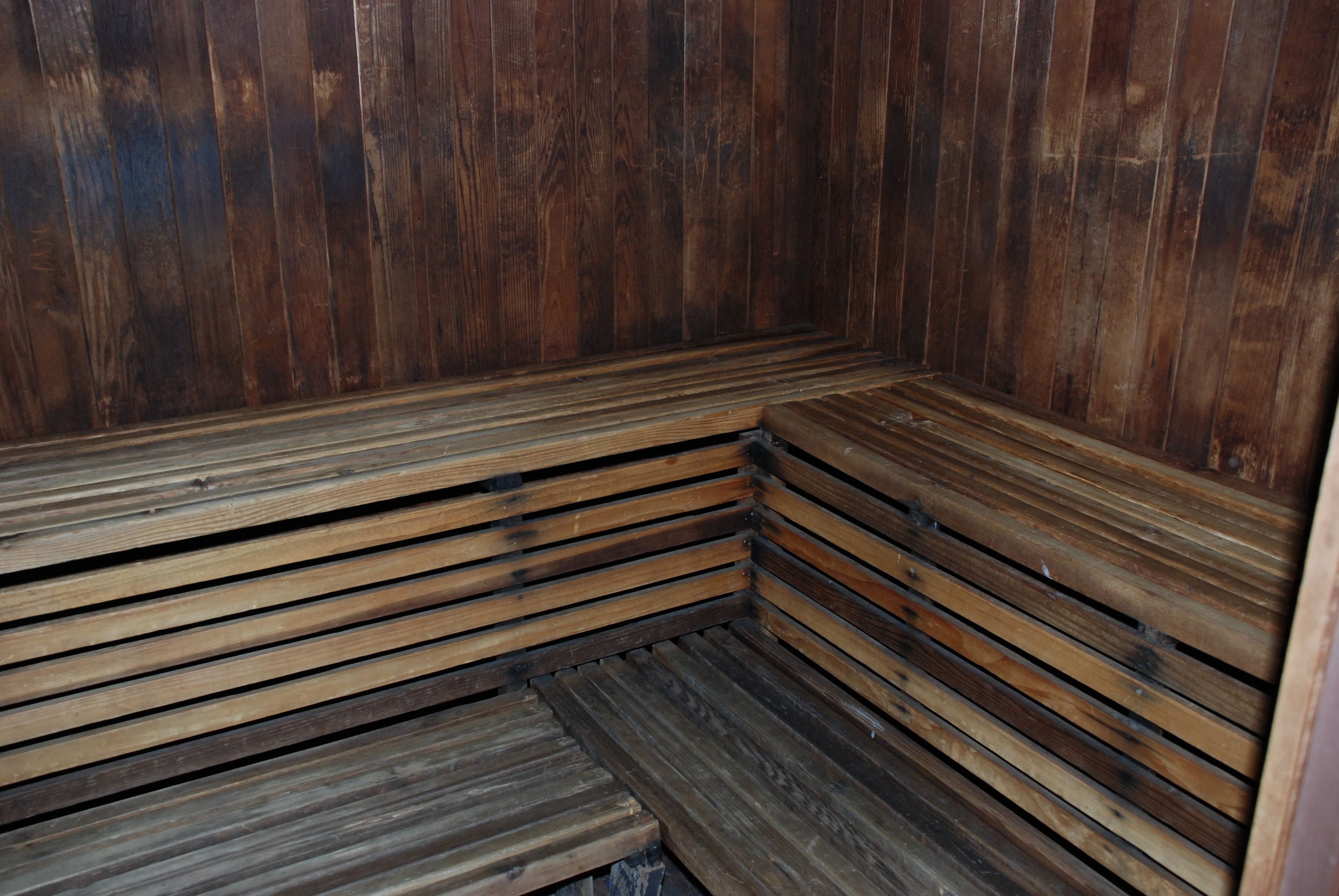 A wooden sauna with benches and a bench seat.
