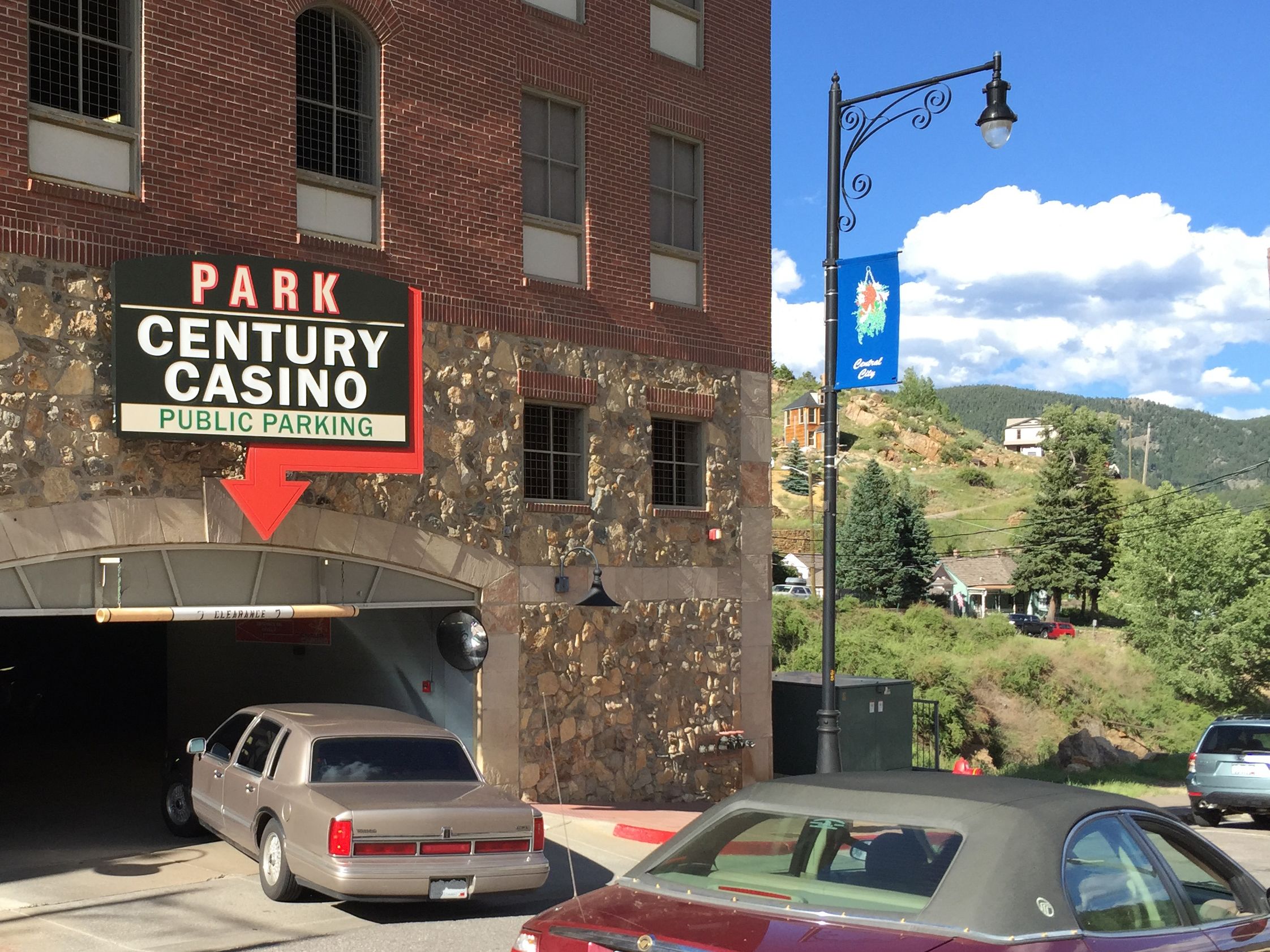Entrada a un estacionamiento con un cartel que indica Estacionamiento Público Century Casino.