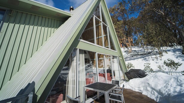 A modern, triangular-shaped building with large windows and a wooden deck. - Ripparoo Ski Lodge (Falls Creek)