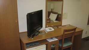 A compact hotel room with a wooden desk, a television, a telephone, and a small refrigerator. - Toyooka Park Hotel (Toyooka)
