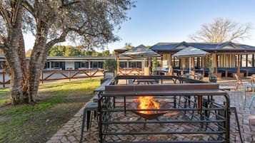 An outdoor seating area with a fire pit, tables, and chairs.