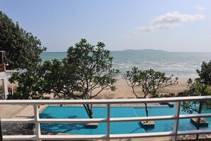 Ein Poolbereich mit Blick auf Strand und Meer.