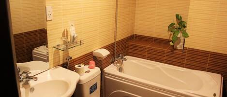 Une salle de bain avec un lavabo, des toilettes et une baignoire.