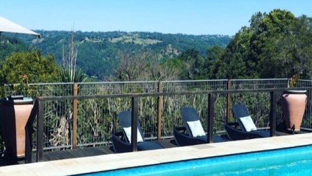 A pool with lounge chairs and a view of the landscape.