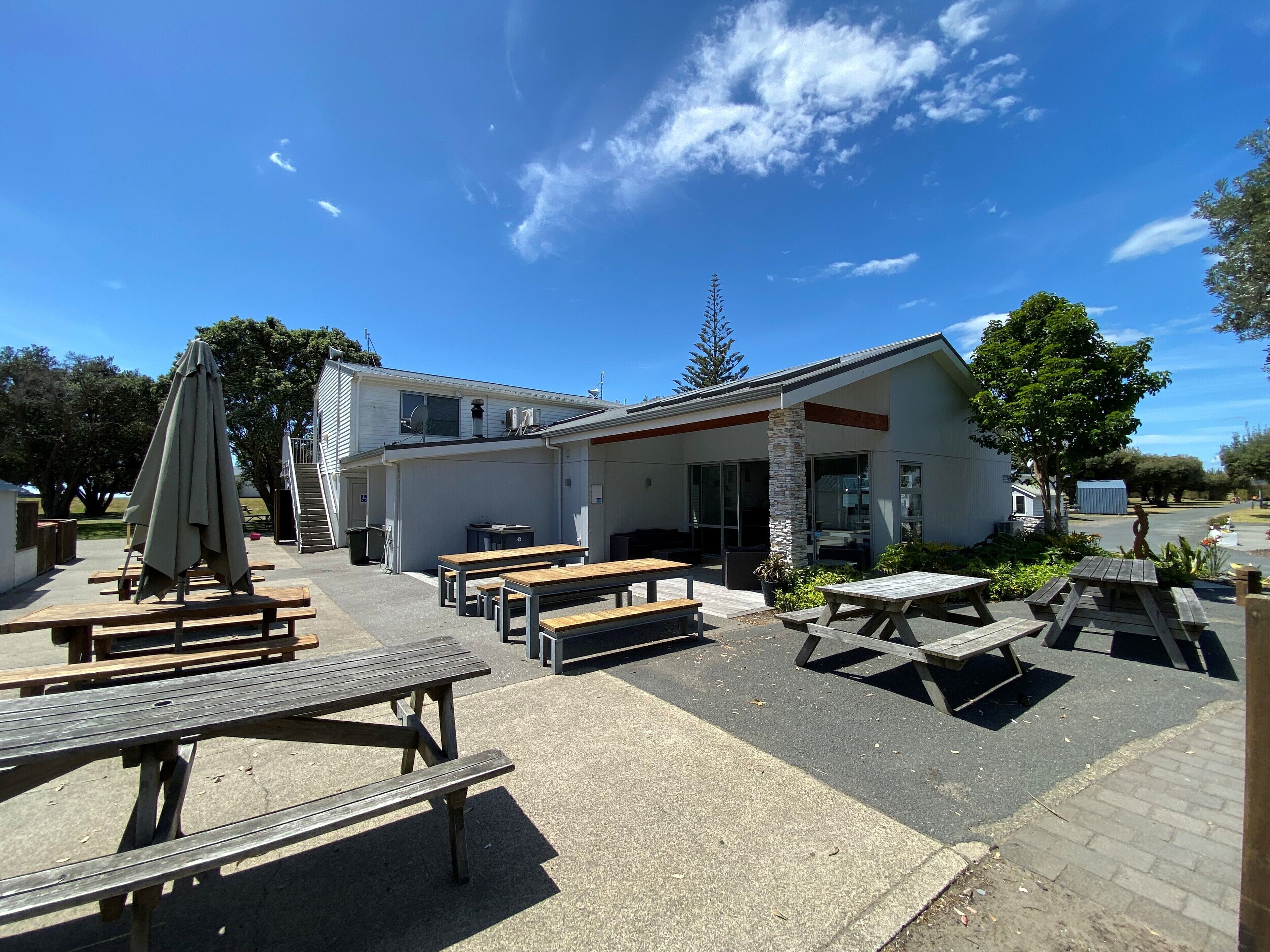An outdoor patio area with picnic tables and a covered seating area.