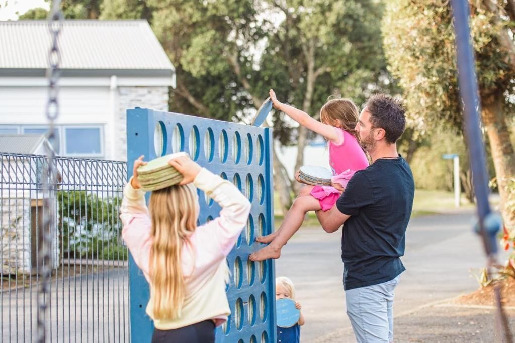A family interacting with a blue playground structure.