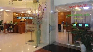 A hotel lobby with a reception desk, a massage parlor, and a Sunflowers Hotel sign. - Hoang Yen Canary Hotel (Quy Nhon)