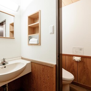 Un bagno con un mobile lavabo in legno, un lavandino e un water.