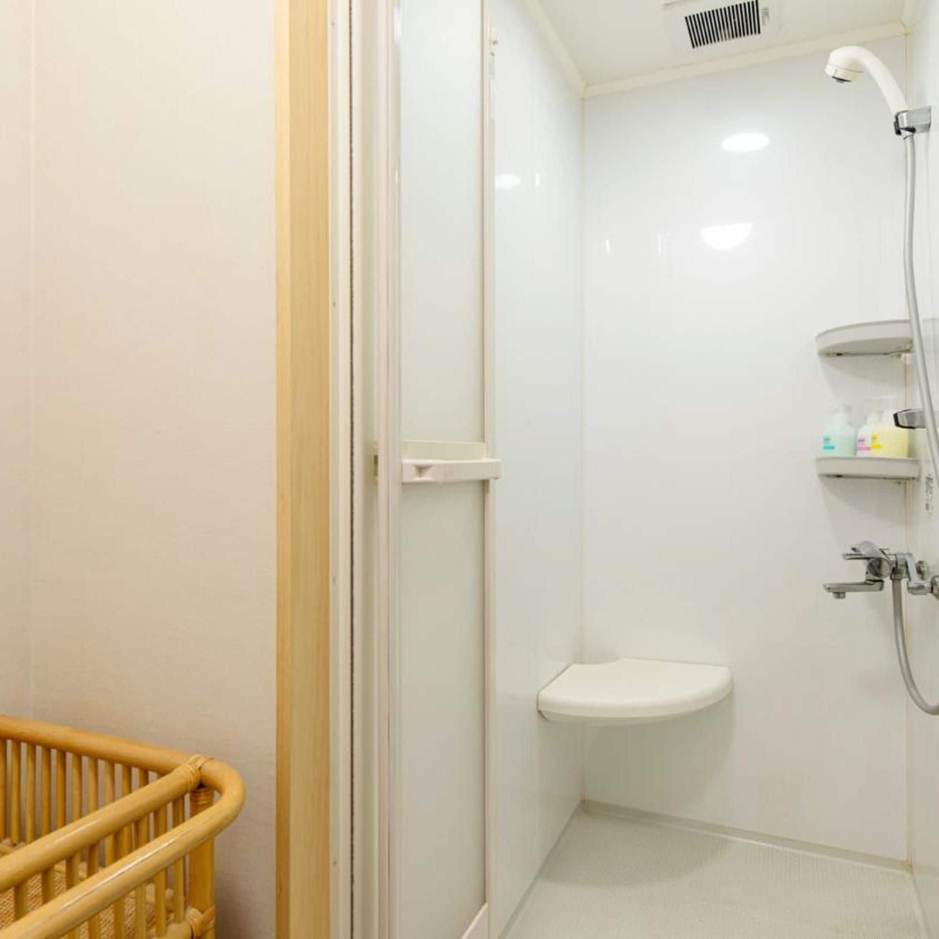 A bathroom with a shower, a toilet, and a baby changing station.