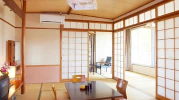 A traditional Japanese room with tatami flooring, a low table, and sliding doors.