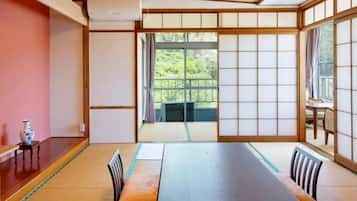 Une pièce de style japonais traditionnel, avec un sol recouvert de tatamis, une table basse et des portes coulissantes.